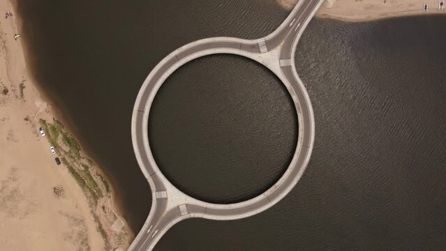 Aerial top down view over unusual circular shape bridge, Laguna Garzon. Uruguay, South America.
