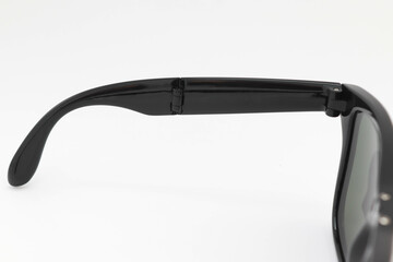 Black folding sunglasses leg isolated on white background closeup.