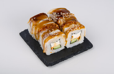 close-up, on a white table, on a black stand, Japanese rolls with eel, cucumber and cream cheese