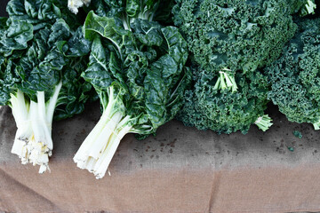 Green chard on a rustic jute table cloth at a  fresh produce farmers market 