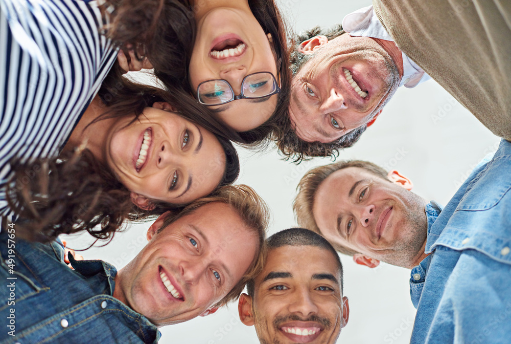 Poster everything is possible with a team of creative minds. low angle shot of six people putting their hea