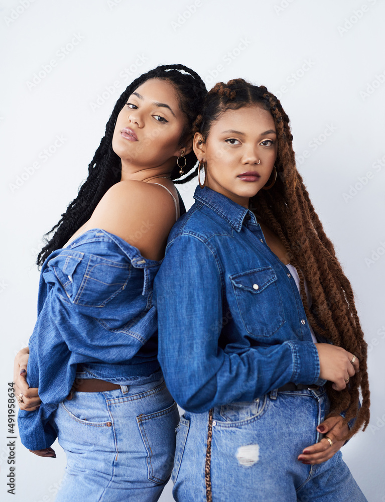 Sticker Looking funky and fresh. Studio shot of two beautiful young women posing against a grey background.