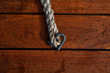 Nautical rope with carabiner on wooden boat jetty