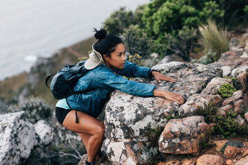 Young woman climbing on a mountain. Sporty woman on a hike.