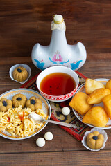 Kazakh still life on Nauryz, with national food: baursaks, zhent, kurt, chak chak and tea on a wooden background