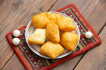 Kazakh still life on Nauryz, with national food: baursaks, zhent, kurt, chak chak and tea on a wooden background
