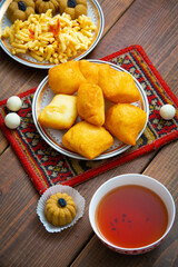 Kazakh still life on Nauryz, with national food: baursaks, zhent, kurt, chak chak and tea on a wooden background