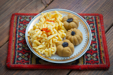 Traditional oriental sweet dessert zhent with raisins and chak chak in a plate on a wooden background