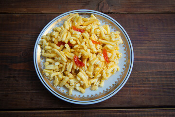 Traditional oriental sweet dessert chak-chak with dried apricots in a plate on a wooden background