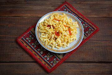Traditional oriental sweet dessert chak-chak with dried apricots in a plate on a wooden background