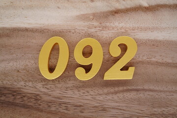Golden Arabic numerals on a real brown and white wooden floor number 092