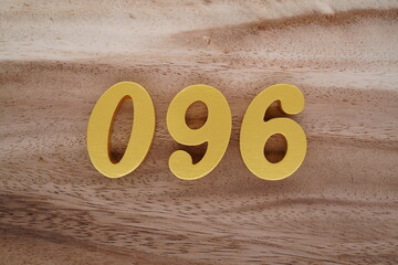 Golden Arabic numerals on a real brown and white wooden floor number 096