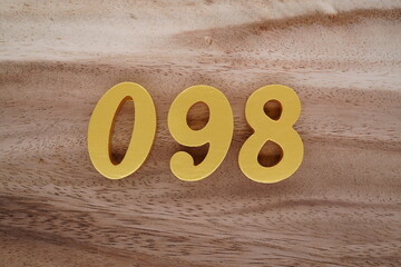 Golden Arabic numerals on a real brown and white wooden floor number 098