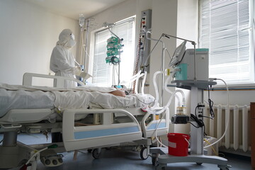 Almaty, Kazakhstan - 06.18.2021 : The doctor regulates the IV for a patient with covid 19