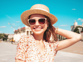Young beautiful smiling hipster woman in trendy summer clothes. Sexy carefree woman posing on the street background at sunset. Positive model outdoors. Cheerful and happy in sunglasses and hat