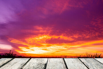 Fototapeta na wymiar wooden bridge and natural sunset sky landscape There was a cloud of mist from above against the orange and pink sky at the dramatic sunset.
