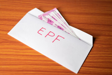 Epf money inside the envelope at table - concept of investment, employment benefit and growth