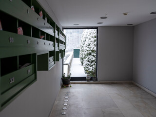 wooden mailboxes at the entrance of the apartment on a snowy day