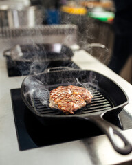Cooking beef steak on a grilling pan in the kitchen