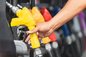 Car refueling on the petrol station. male employees controlled the fuel pump with Fuel nozzles adding gasoline fuel in car at a pump gas station.