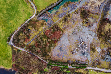 Aerial view on an old abandoned open quarry with small pool of water. Stone for construction industry. Nature scene. County Galway, Ireland. Industrial impact on ecology and environment.