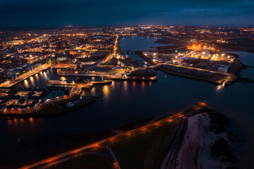 Galway city illuminated at night, port area. Aerial high point view. Dark scene. Town at night. Popular travel destination. Business and educational center. City lights glow in the dark.
