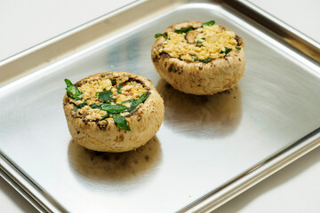 Stuffed mushrooms on a metal tray. Food industry product.