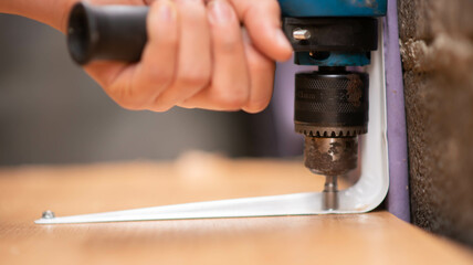 Boy teenager use screwdriver fix wood table