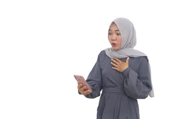 Wow and surprised asian muslim woman standing while getting a news from her phone. Isolated on white