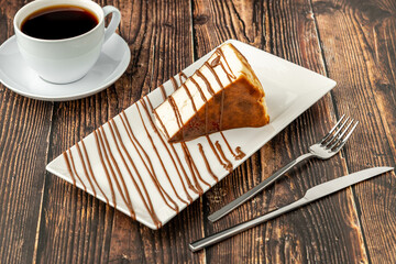 Sliced san sebastian cheesecake with coffee on wooden table