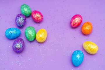 Multi-colored Easter eggs on a purple background. Holiday concept with copy space.