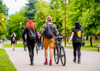 A guy and a girls walk along the path in the city Park
