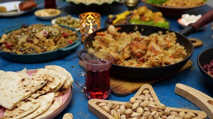 Moroccan tea. Ramadan iftar Eid. Muslim family has dinner at home. Falafel, samosa, chickpeas, beans, pita bread, pilaf, tajine, couscous, dates, olives. Eid Al Fitr holiday celebration