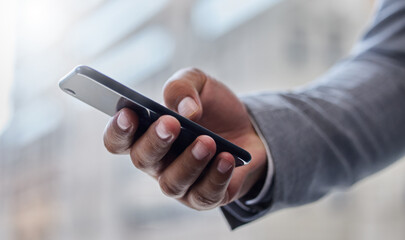 Working on the go. Shot of a businessperson using a smartphone.
