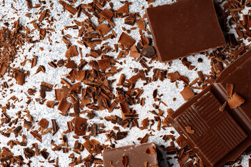 Grated chocolate and pieces of tasty chocolate on table