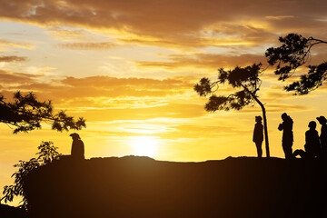 Fototapeta premium silhouette people on mountain with sunset background
