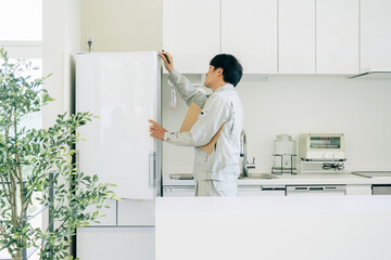 キッチンと作業着姿の男性（冷蔵庫）
