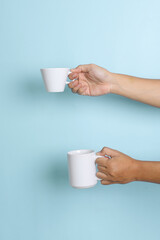 Fototapeta na wymiar Cup and mug mock up. Hand held cup and mug on blue background