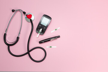 Diabetes equipment, glucose level blood test on pink background with copy space. Diabetic items to...