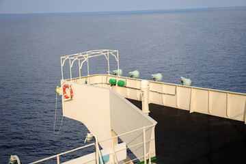 View of port side bridge wing of a cargo ship with Man overboard marker and lifebuoy.