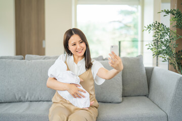 赤ちゃんと写真を撮る女性
