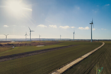 Wiatraki produkują zieloną energię odnawialną z wiatru, piękne ujęcie na farmę wiatraków na polu  © Slawek