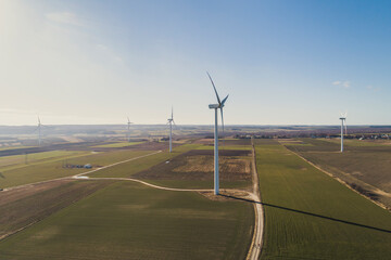 Turbiny wiatrowe, wiatraki produkują energię odnawialną z wiatru na pięknych malowniczych polach oświetlone słońcem