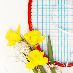 Tennis. Holiday sport composition with tennis racket with bouquet of daffodils on a white...