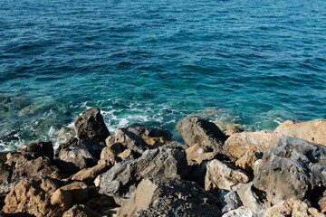 Fototapeta na wymiar rocky coast, sea waves lap the pebble beach, azure water, Crete, Greece