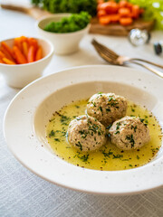 Boiled meatballs in dill sauce on white table
