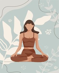 A girl does yoga in a yoga studio, sits and meditates in the lotus position