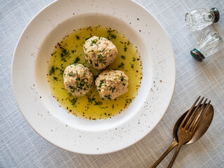 Boiled meatballs in dill sauce on white table

