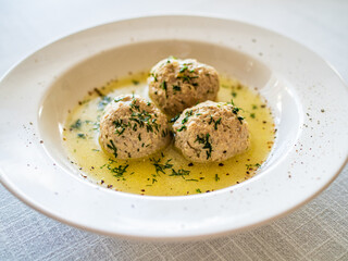 Boiled meatballs in dill sauce on white table
