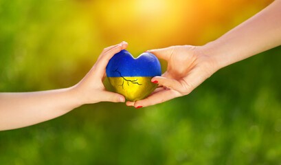 Pomoc Ukrainie, pomocna dłoń pomaga skrzywdzonej Ukrainie. Ukraina